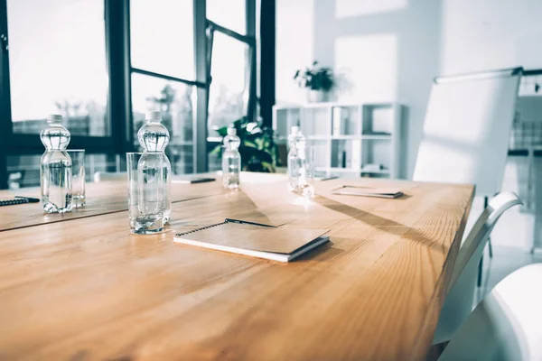 Empty conference hall with bottles of water and notebooks — Stock Photo