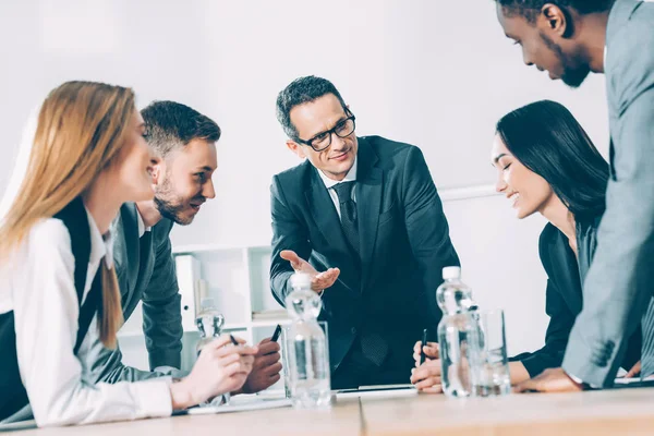 Uomini d'affari multirazziali che conversano in sala conferenze — Foto stock