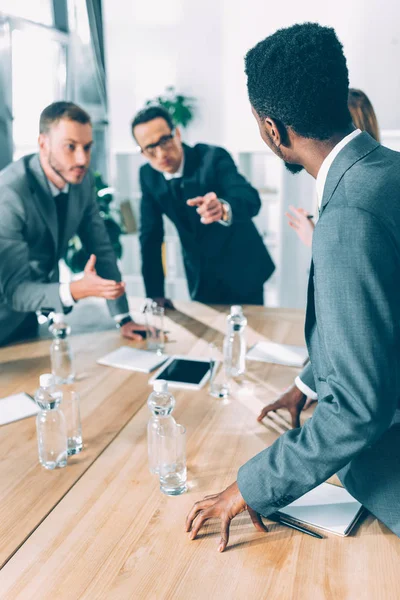 Uomini d'affari multirazziali che conversano nella sala conferenze — Foto stock