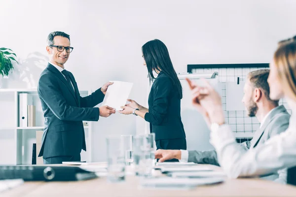 Boss rewarding asian manageress at modern office — Stock Photo