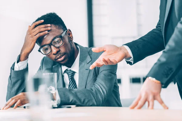 Partial view of exhausted african american businessman listening to boss — Stock Photo