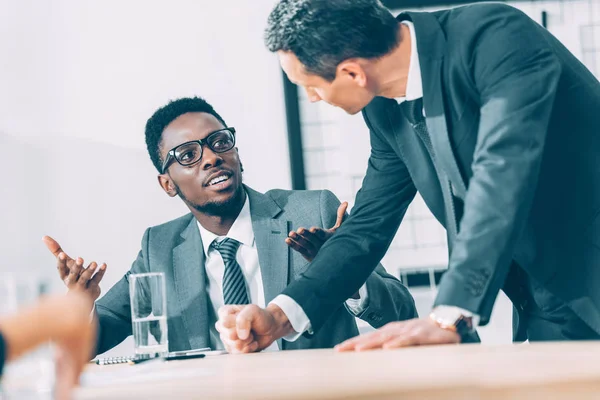 Empresarios multiétnicos conversando en la oficina - foto de stock