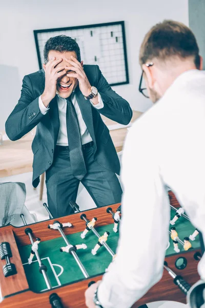 Homens de negócios jogando futebol de mesa no escritório moderno — Fotografia de Stock