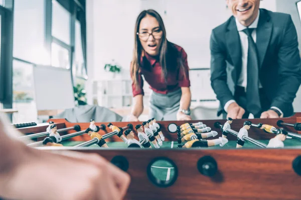 Primer plano de los empresarios jugando al futbolín en la oficina moderna - foto de stock