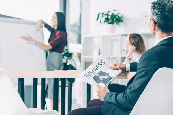 Empresário segurando jornal e ouvindo apresentação em conferência — Fotografia de Stock