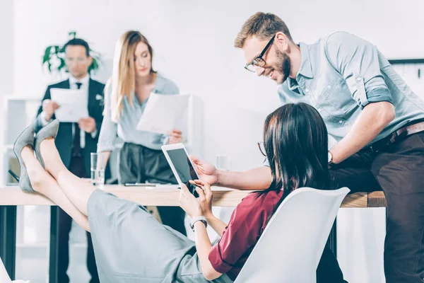 Junge Geschäftspartner mit digitalem Tablet im Konferenzsaal — Stockfoto