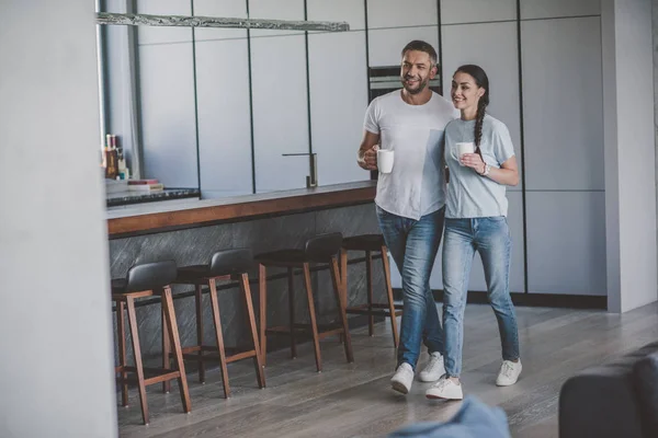 Coppia sorridente con tazze di caffè in cucina a casa — Foto stock