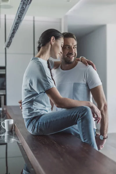 Coppia sorridente che si abbraccia in cucina a casa — Foto stock