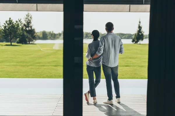 Back view of couple standing at porch of country house — Stock Photo