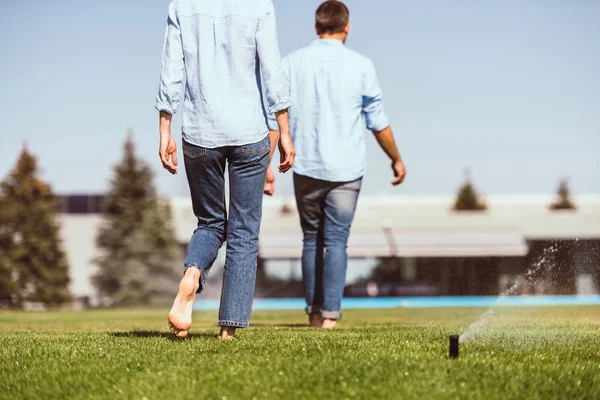 Vista parcial de pareja despertando en césped verde cerca de casa de campo — Stock Photo