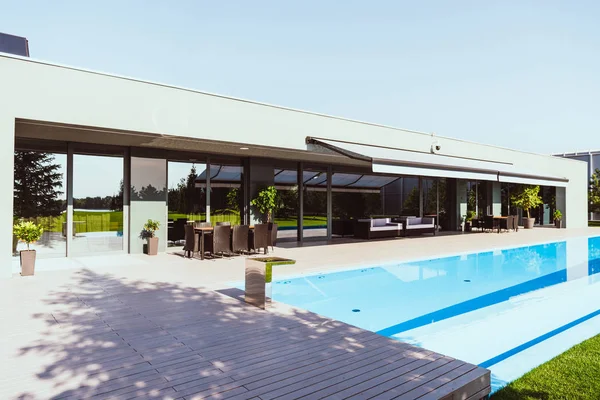 Hermosa casa moderna con piscina al aire libre bajo cielo azul claro - foto de stock