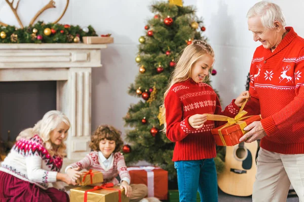 Nonni e adorabili bambini con scatole regalo trascorrere del tempo insieme a Natale — Foto stock