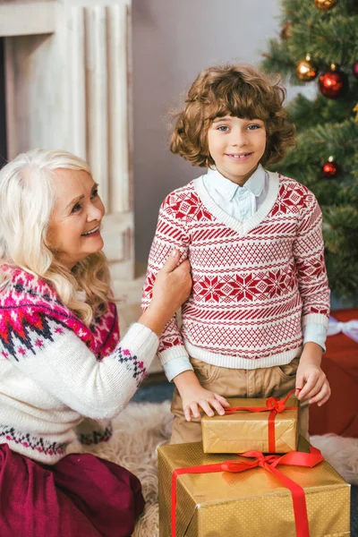 Nonna e suo nipote con regali di Natale guardando la fotocamera — Foto stock