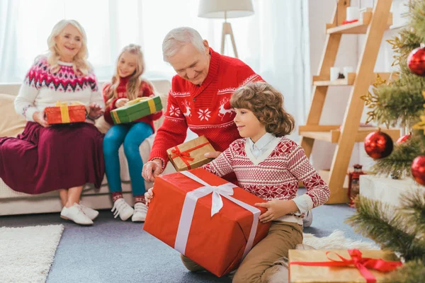 Nonni e bambini con scatole regalo trascorrere del tempo insieme a Natale — Foto stock