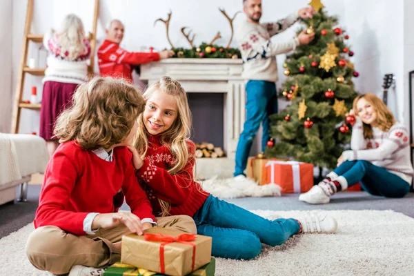Heureux frères et sœurs sititng sur le sol ainsi que des cadeaux pendant la veille de Noël — Photo de stock