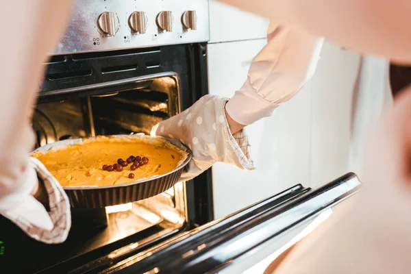 Plan recadré fo femme sortant tarte à la citrouille du four — Photo de stock