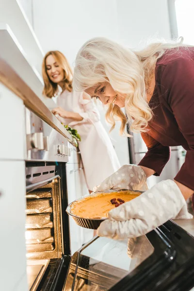 Heureux mère aînée et fille cuisson tarte à la citrouille ensemble à la maison — Photo de stock