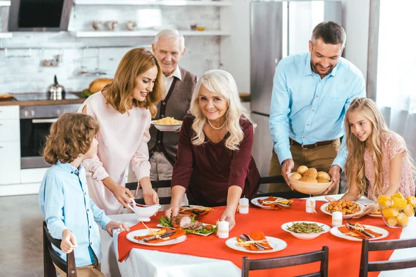 Happy family serving table together at home during thansgiving — Stock Photo