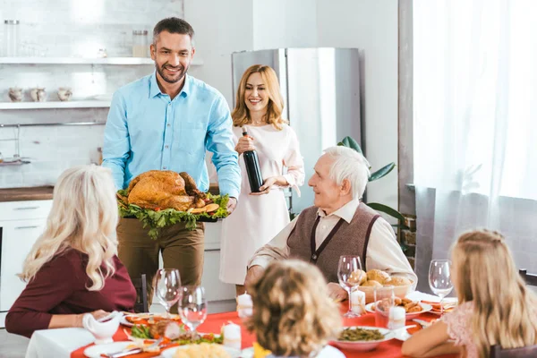 Happy family with turkey celebrating thanksgiving day at home — Stock Photo