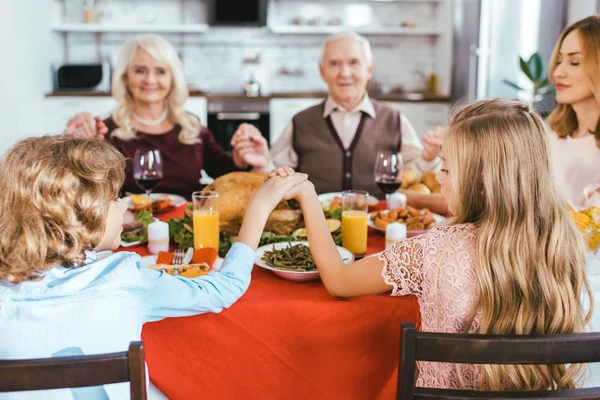Beautiful happy family praying before thanksgiving dinner — Stock Photo