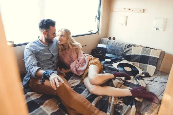 Beautiful hippie couple relaxing inside campervan and listening vinyl records — Stock Photo