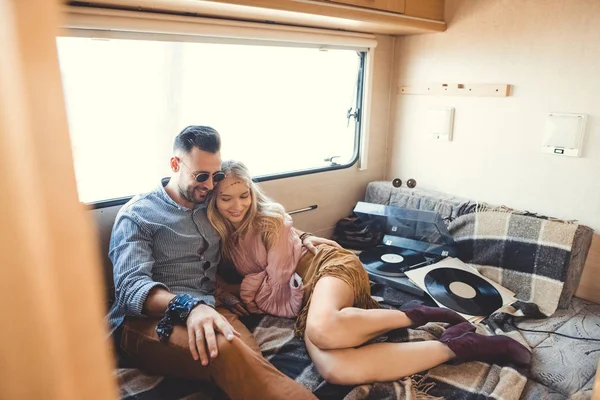 Hippie couple listening music on vinyl records inside trailer — Stock Photo