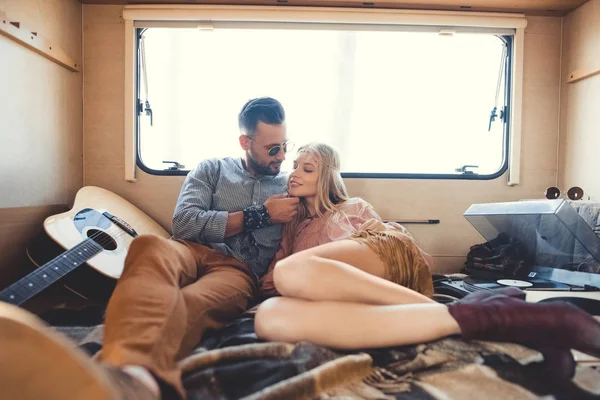 Hippie couple hugging inside campervan with acoustic guitar and vinyl player — Stock Photo