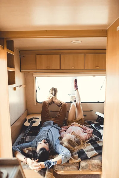 Young hippie couple resting inside trailer with guitar and vinyl player — Stock Photo