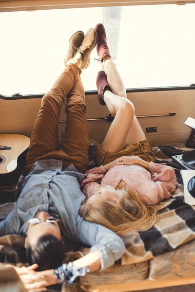 Hippie pareja descansando dentro campervan con guitarra y vinilo jugador - foto de stock