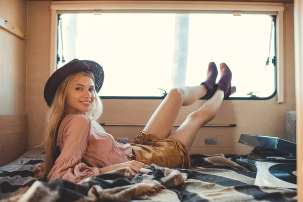 Atractiva chica hippie tumbado dentro autocaravana con reproductor de vinilo y registros - foto de stock
