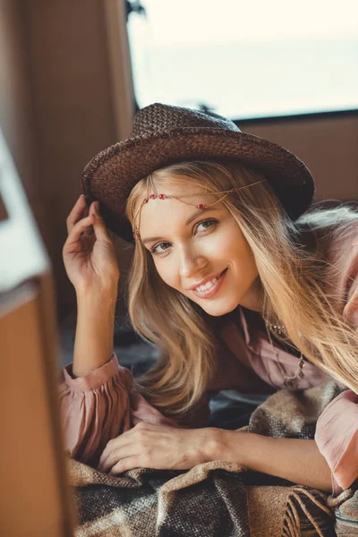 Attractive hippie girl in hat lying inside trailer — Stock Photo