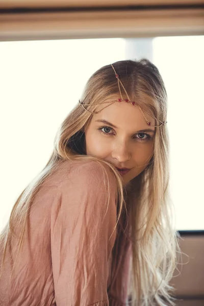 Beautiful blonde hippie girl in hair decoration looking at camera — Stock Photo