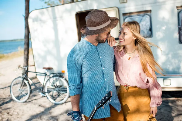 Novio y novia abrazando cerca campervan con bicicleta - foto de stock