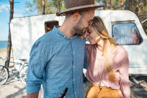 Beau couple hippie embrassant près de camping-car dans la forêt — Photo de stock