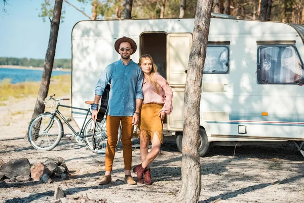 Young couple of campers posing near trailer — Stock Photo