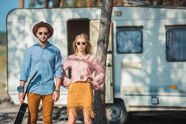 Jeune hippie couple de campeurs posant près de remorque — Photo de stock