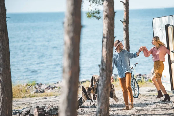 Hippie coppia che si tiene per mano e camminare nella natura vicino camper — Foto stock