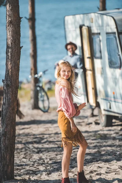 Attractive young woman dancing while man playing guitar near campervan — Stock Photo