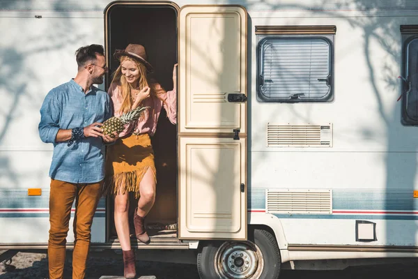 Par de campistas com abacaxi posando perto de campervan — Fotografia de Stock