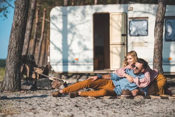 Hippie young couple relaxing on blanket near camper van — Stock Photo