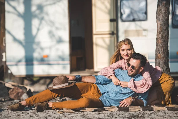 Hippie pareja acostado en manta cerca camper van - foto de stock