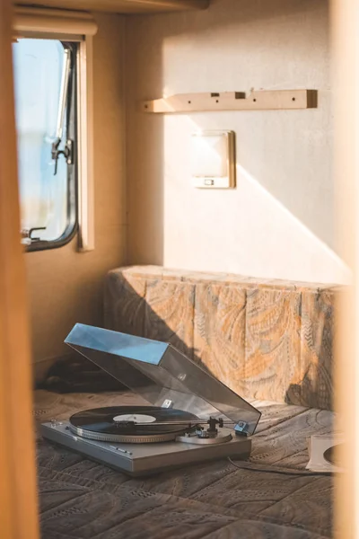 Vintage vinyl player with record inside of campervan with sunlight — Stock Photo