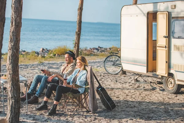 Glückliches Paar mit einem Glas Wein bei einem Picknick in der Nähe von Wohnmobil — Stockfoto