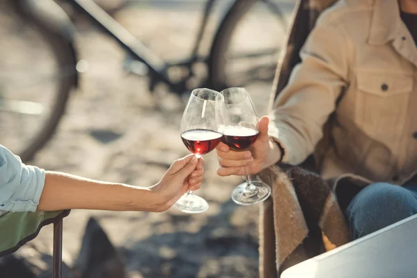 Vista parcial de pareja tintineando con copas de vino durante un picnic — Stock Photo