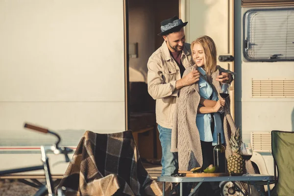 Handsome man wearing warm sweater on his girlfriend near campervan — Stock Photo