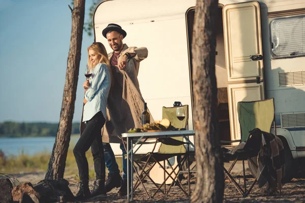 Homem vestindo camisola quente em sua namorada perto de campervan — Fotografia de Stock