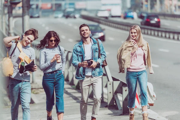 Giovani amici con mappa e zaini che viaggiano insieme in una nuova città — Foto stock