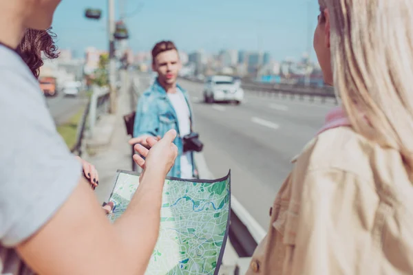 Partial view of travelers looking for destination on map during trip in new city — Stock Photo