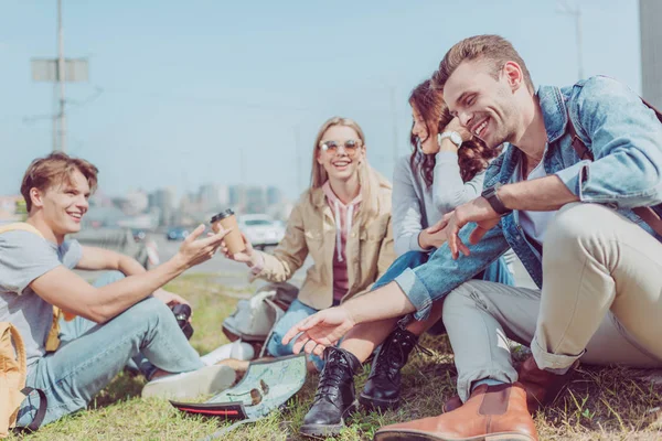 Glückliche junge Freunde ruhen sich im Urlaub auf grünem Gras aus — Stockfoto