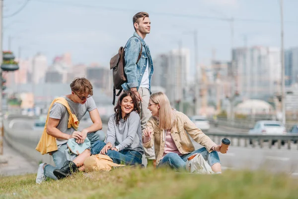 Gruppe junger lächelnder Reisender mit Rucksäcken in neuer Stadt — Stockfoto